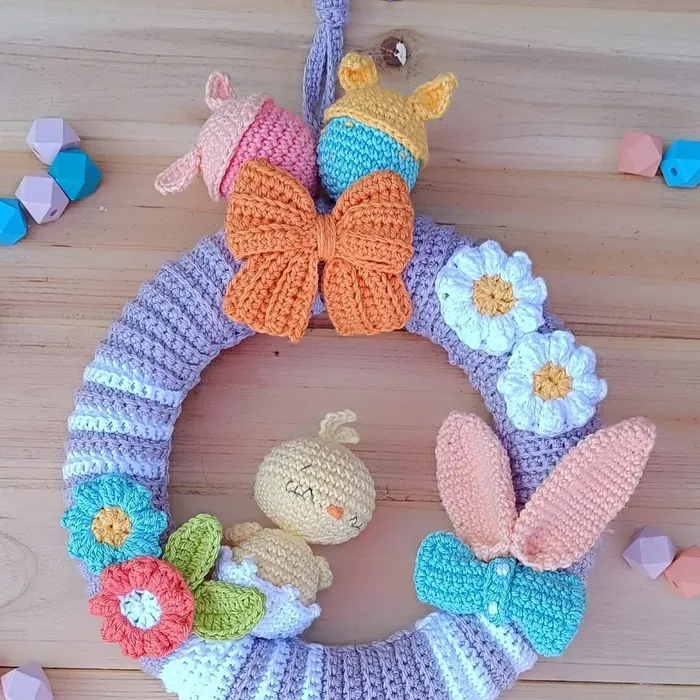 Guirnalda de pared infantil Spring & Blossom tejida a mano en forma de corona con flores de crochet en tonos pastel.