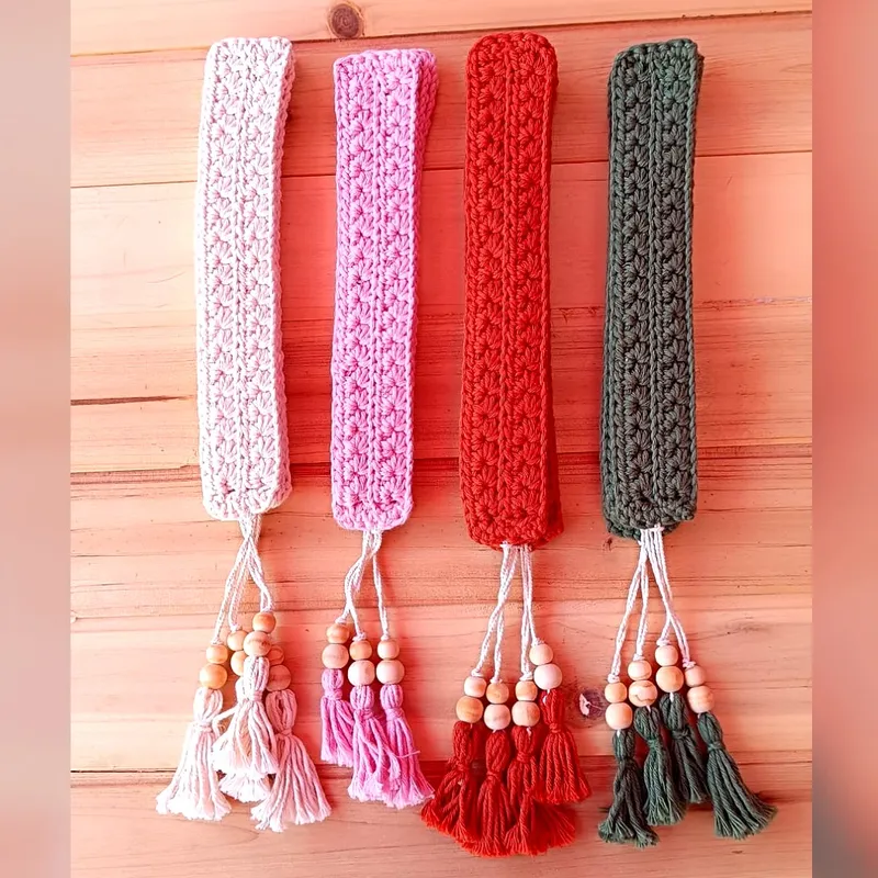 Marcapáginas de crochet con borlas y cuentas junto a varios libros