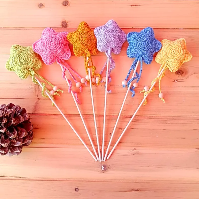 Varita mágica de crochet con estrellas de colores, palo en tono claro y cuentas decorativas